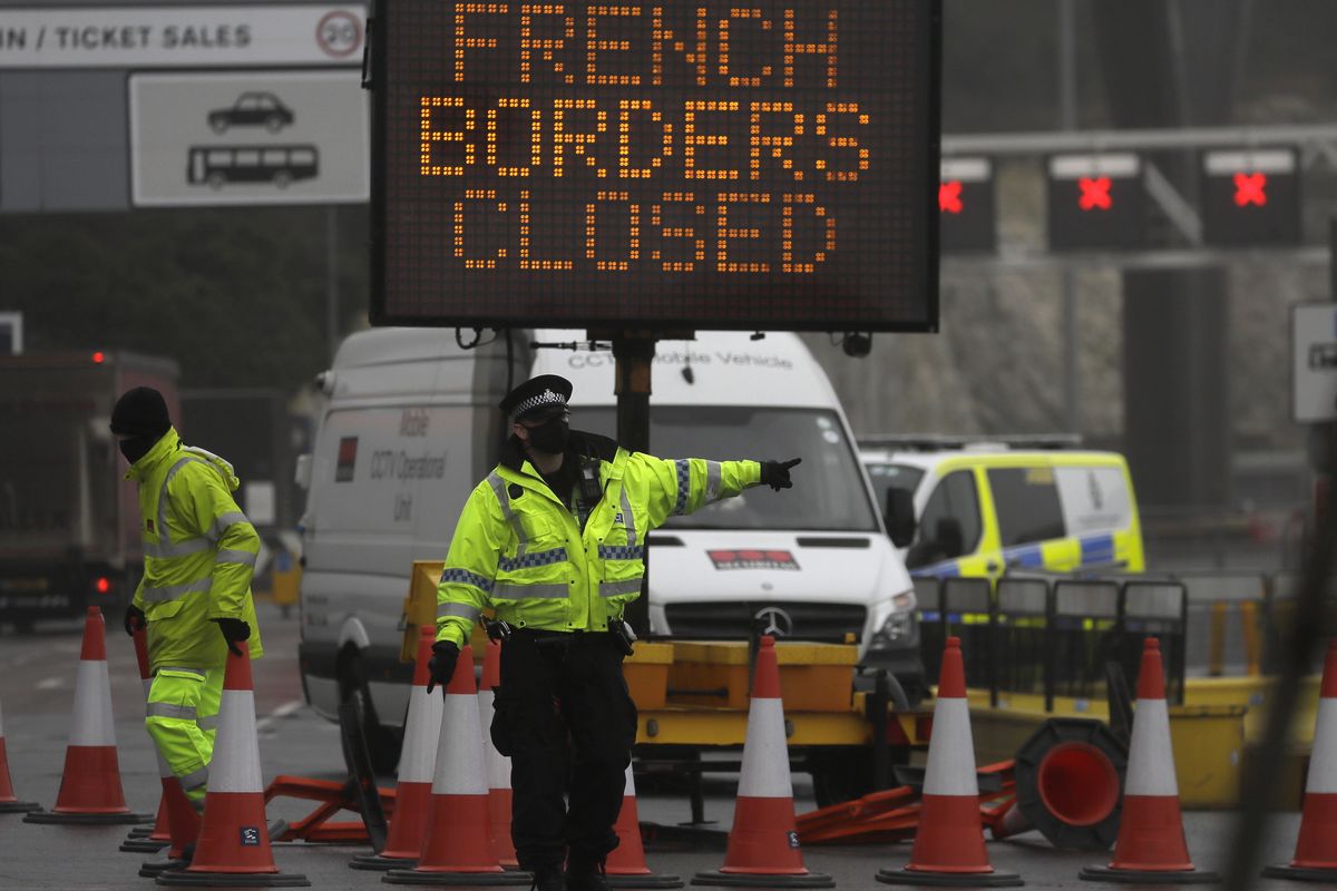 A police officer directs traffic at the entrance to the closed ferry terminal in Dover, England on Monday after the Port of Dover was closed and access to the Eurotunnel terminal suspended following the French government