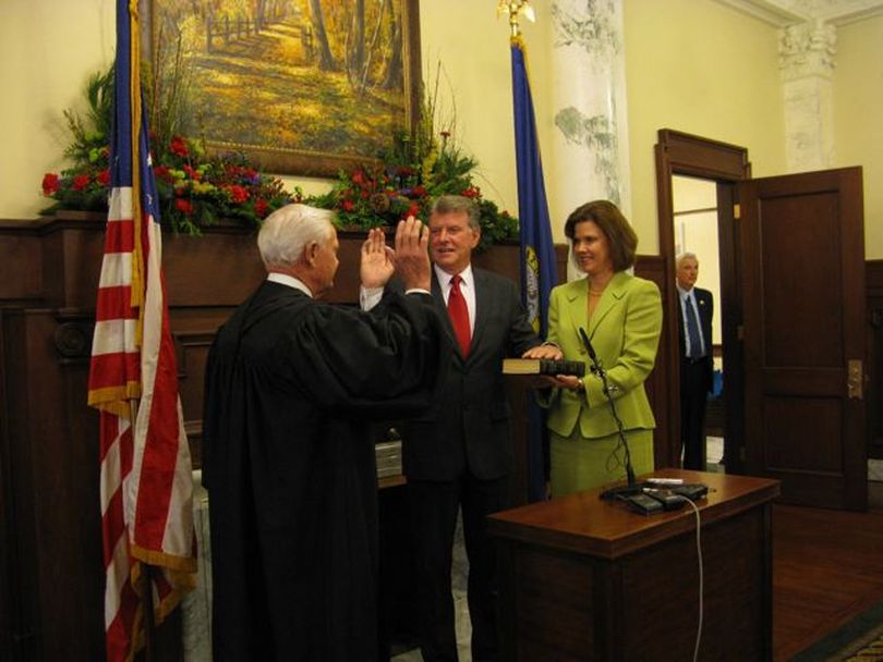 Idaho Gov. Butch Otter takes the oath of office, administered by U.S. District Judge Ed Lodge, left. At right is Idaho First Lady Lori Otter. (Betsy Russell)