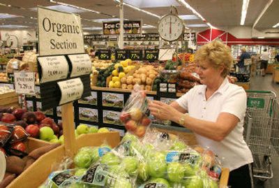 
Dorothy Robinson of Scottsdale, Ariz., checks the organic apples at Sprout's in Scottsdale. Organic products have a tiny slice, about 2.5 percent, of the nation's food market, but the slice is expanding at a feverish pace with demand outstripping supply. 
 (Associated Press / The Spokesman-Review)