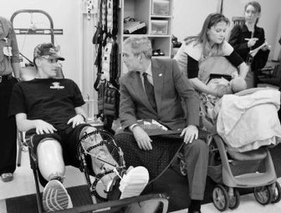 
President Bush talks with Sgt. David Gardner, of  Ft. Bragg, N.C., who was wounded in Iraq,  during a visit Friday with patients at  Walter Reed Army Center  in Washington. At right is Gardner's wife, Beverly, and daughter, Hailey. 
 (Associated Press / The Spokesman-Review)