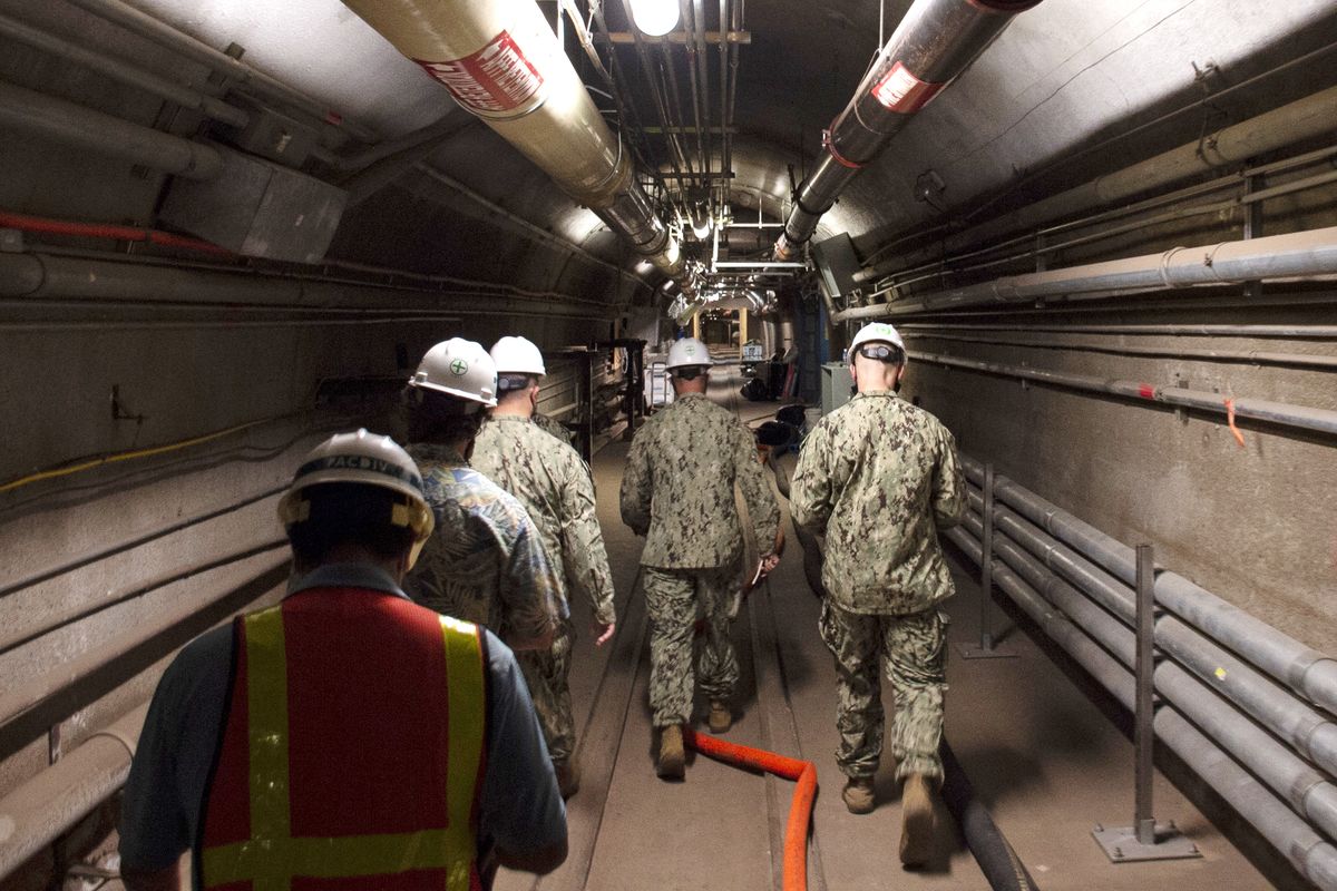 FILE - In this Dec. 23, 2021, photo provided by the U.S. Navy, Rear Adm. John Korka, Commander, Naval Facilities Engineering Systems Command (NAVFAC), and Chief of Civil Engineers, leads Navy and civilian water quality recovery experts through the tunnels of the Red Hill Bulk Fuel Storage Facility, near Pearl Harbor, Hawaii. Native Hawaiians who revere water in all its forms as the embodiment of a Hawaiian god say the Navy