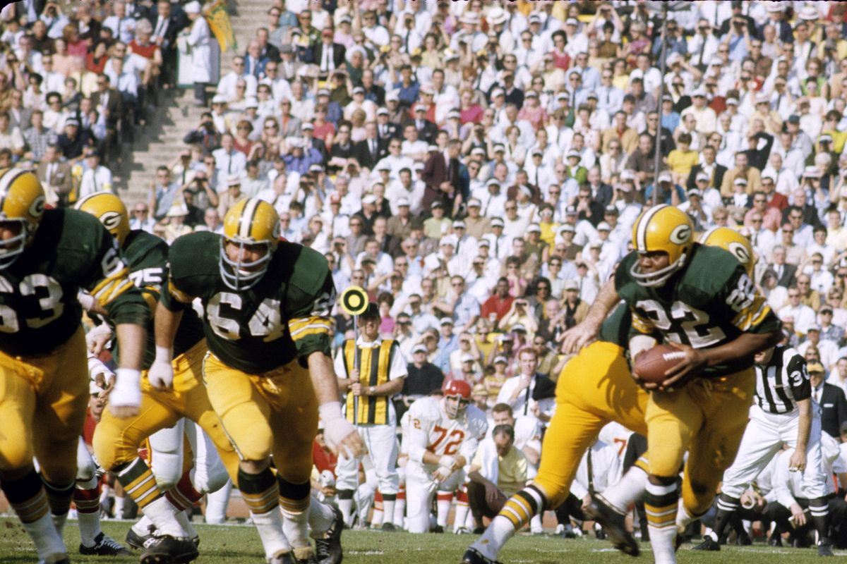 Green Bay Packers running back Elijah Pitts (22) follows guards Fuzzy Thurston (63) and Jerry Kramer (64) on the famed Packers Sweep during Super Bowl I, a 35-10 victory over the Kansas City Chiefs on January 15, 1967, at the Los Angeles Memorial Coliseum. (NFL / Associated Press)