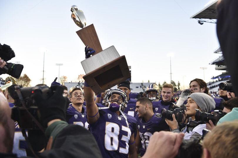 Washington receiver Neel Salukhe (83) hoists the Apple Cup trophy after defeating WSU on Friday, Nov 27, 2015, at Husky Stadium in Seattle, Wash. (Tyler Tjomsland / The Spokesman-Review)