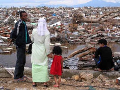 Residents of Banda Aceh, Indonesia, look out at the devastation caused by last month's Tsunami. Aceh province on Sumatra was one of the hardest-hit areas.
(Photo courtesy of Mark Bardwell / The Spokesman-Review)