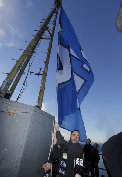 Above Seattle: Musician Dave Matthews raises the Seattle Seahawks 12th Man flag Thursday on the roof of the Space Needle in Seattle. The Seahawks face the New England Patriots in Super Bowl XLIX on Sunday in Glendale, Ariz. (Associated Press)