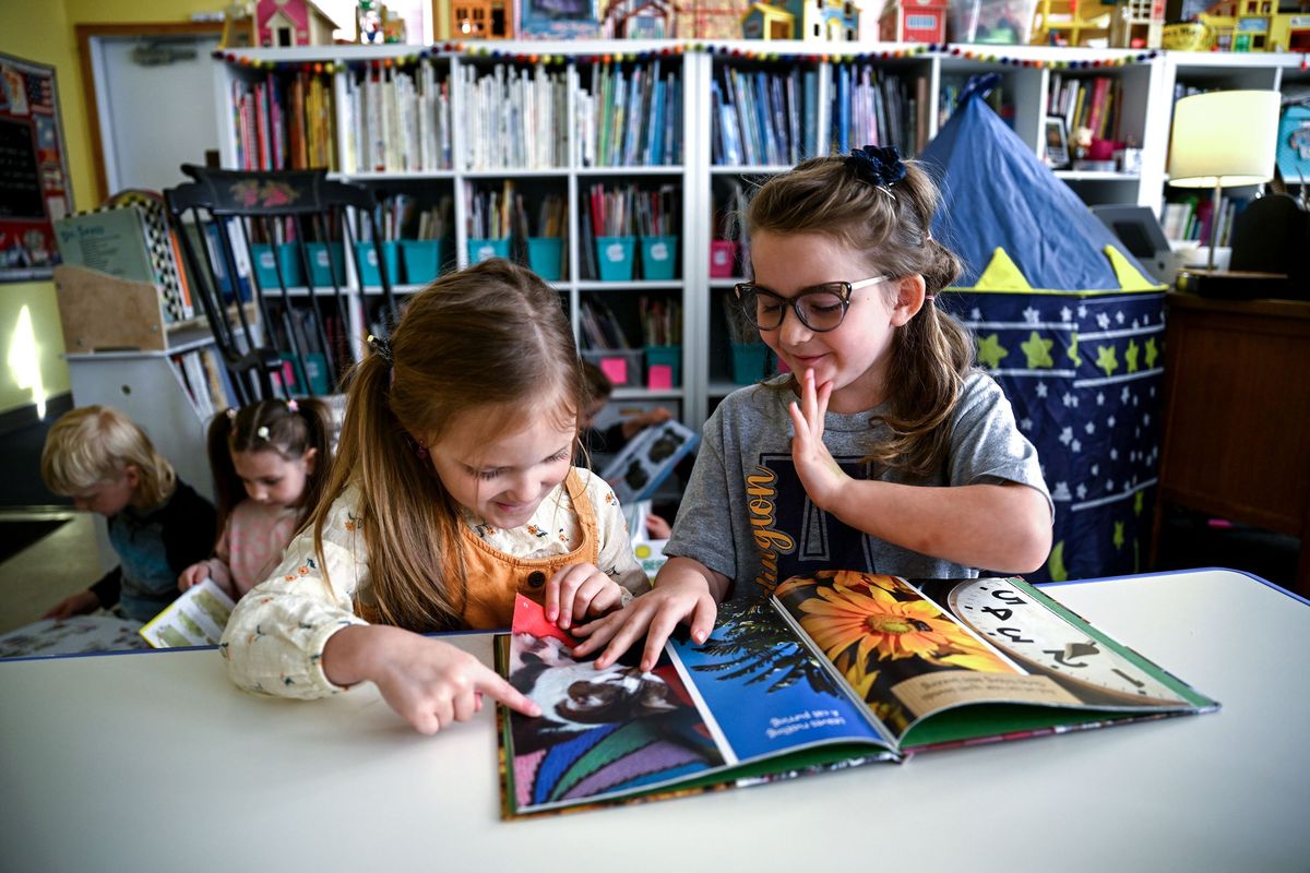 Orchard Prairie kindergartners Harris Mathis, left, and Eleanor Clark smile at a picture of a kitten Oct. 3 at the school built in 1894. (Kathy Plonka/The Spokesman-Review)