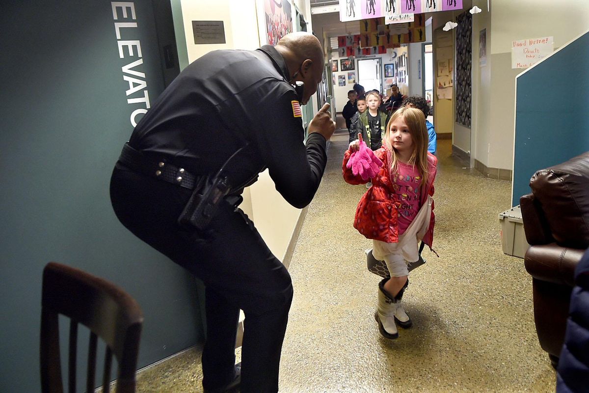 School resource officer Ed Richardson greets kindergartner Emma Gaston as she walks to lunch at Moran Prairie Elementary in Spokane on Thursday, March 9, 2017. Spokane public schools have proposed a change in policy regarding use of force. Kathy Plonka /THE SPOKESMAN-REVIEW (Kathy Plonka / The Spokesman-Review)