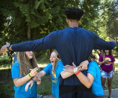 Gonzaga University basketball players Johnathan Williams is embraced by Camp Goodtimes campers after a basketball session, July 11, 2017. (Dan Pelle / The Spokesman-Review)