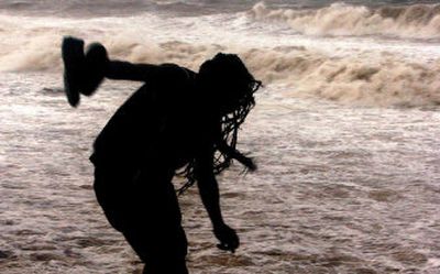 
A Jamaican walks next to waves churned up by Hurricane Emily on Saturday. Fishermen hauled their boats in and workers raced to board up buildings. 
 (Associated Press / The Spokesman-Review)