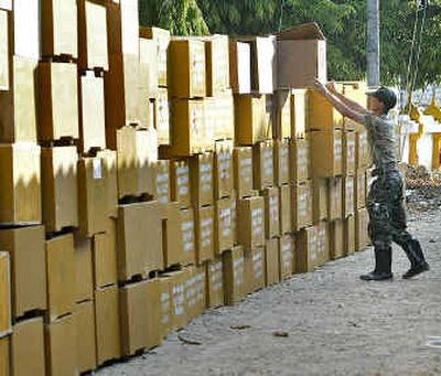 
A Thai soldier stacks coffins in Takuapa in southern Thailand on Friday. Teams of forensic experts took DNA samples Friday as Thailand's government announced its death toll in the tsunami disaster had doubled to more than 4,500.
 (Associated Press / The Spokesman-Review)