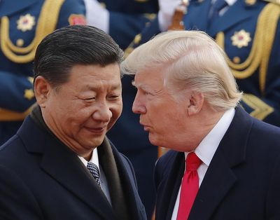 President Donald Trump, right, chats with Chinese President Xi Jinping during a welcome ceremony Nov. 9, 2017, at the Great Hall of the People in Beijing. (Andy Wong / Associated Press)