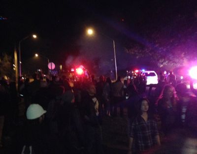 Hundreds of college-age revelers crowd a street late Saturday in Bellingham as police try to disperse the crowd. Multiple partiers were arrested during the melee, according to police. (Associated Press)