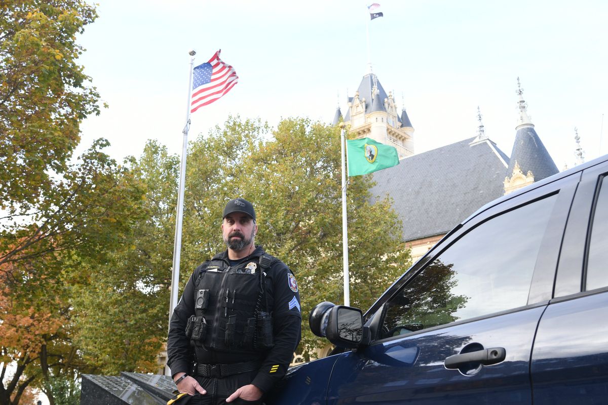 Spokane Police Sgt. Richie Plunkett, a former behavioral health officer known throughout the streets of Spokane for his compassion while policing, stands next to his department car outside the Spokane County Courthouse Oct. 19, 2024.  (James Hanlon/THE SPOKESMAN-REVIEW)