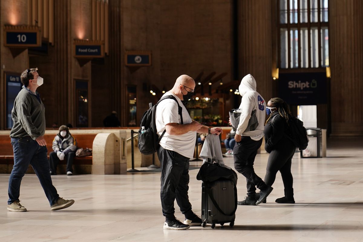 Travelers make their way through the 30th Street Station ahead of the Thanksgiving holiday, Friday, Nov. 20, 2020, in Philadelphia. With the coronavirus surging out of control, the nation