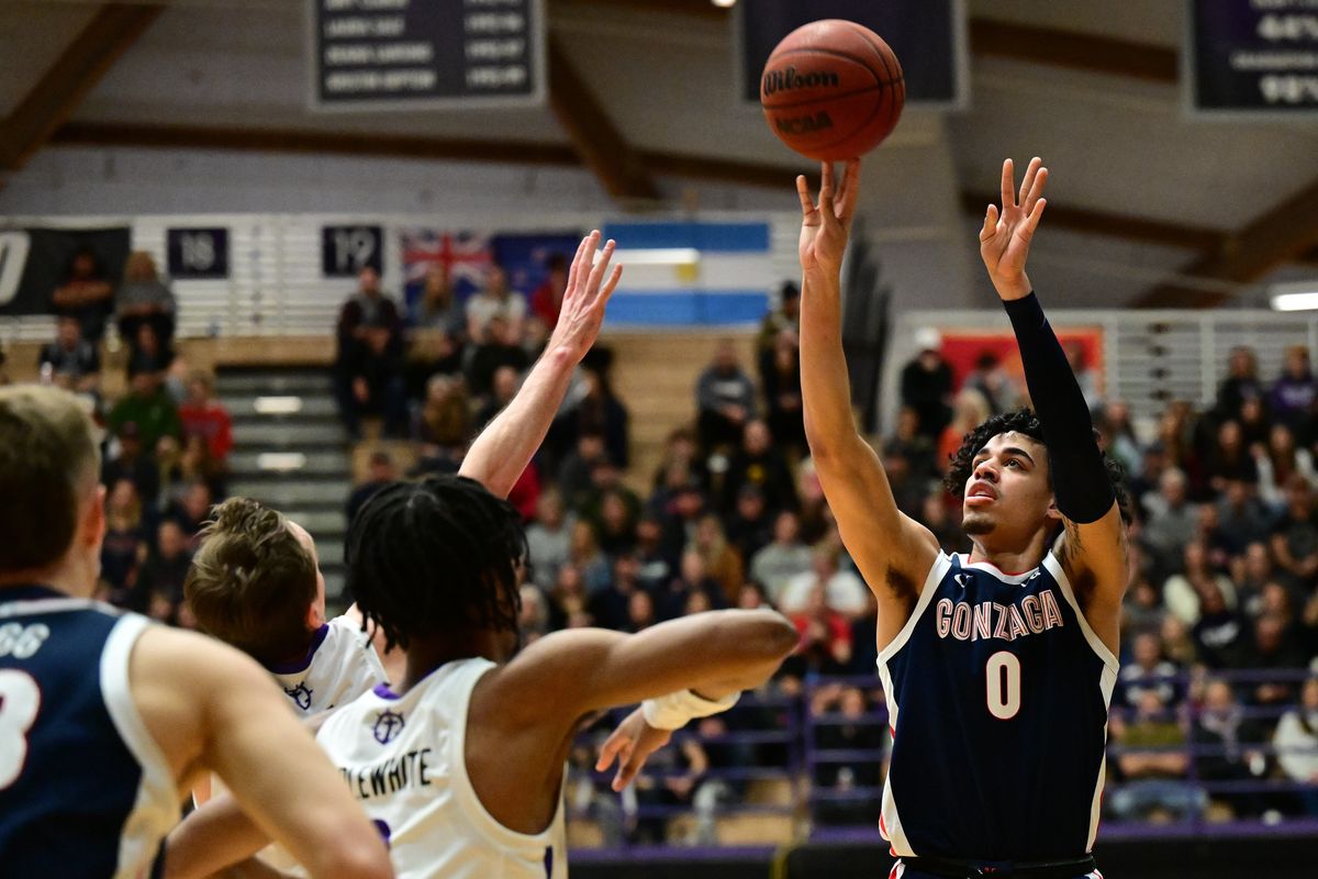 Guard Julian Strawther (0) fires a 3-pointer over defenders during the first half of Gonzaga’s 82-67 road win over Portland on Saturday.  (Tyler Tjomsland/The Spokesman-Review)