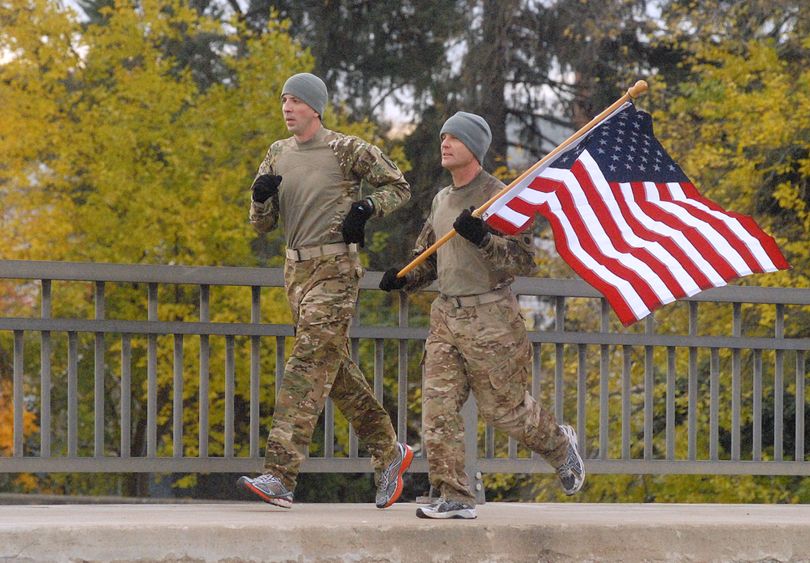 Les Rose, left, and Jay Via, who served in Afghanistan at different times, decided to run more than 13 miles with an American flag, Monday, Nov. 11, 2013 in Troy, Ohio.