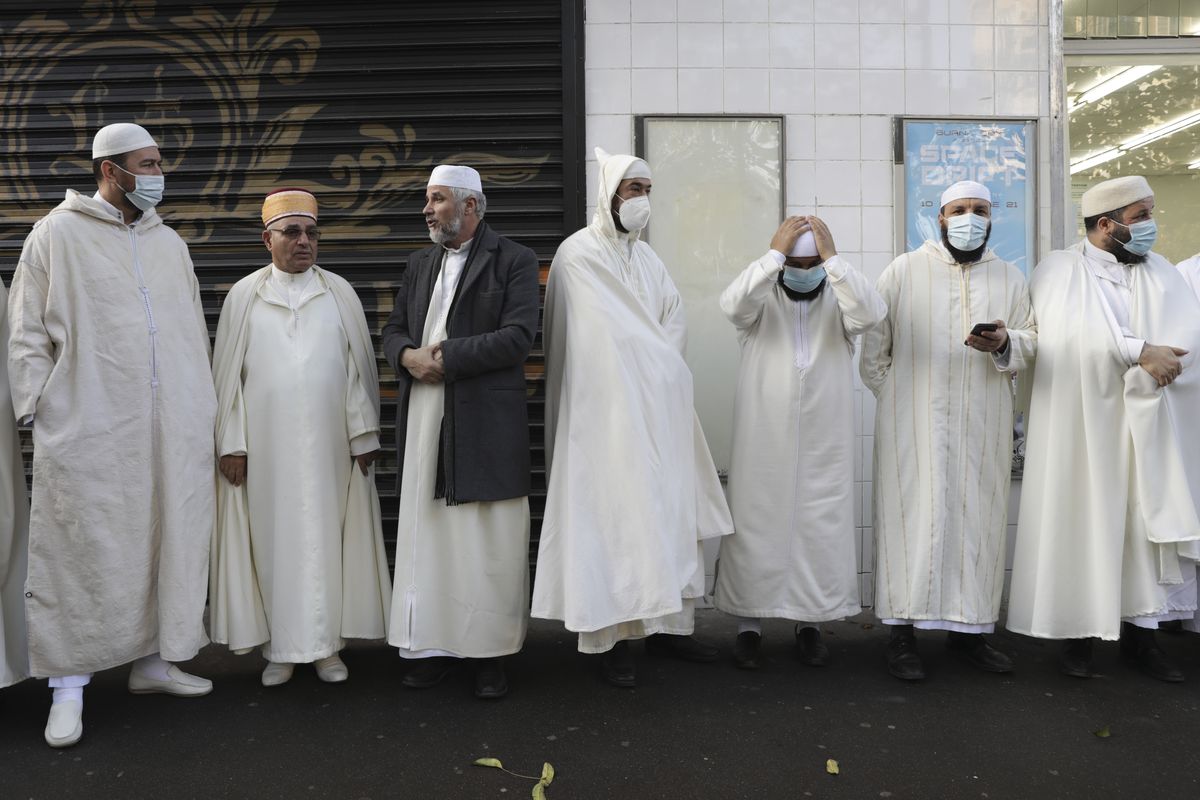 Imams from the Paris Mosque gather before paying their homage to the victims of the Nov. 13, 2015 attacks, near the Bataclan concert hall in Paris, Friday, Nov.12, 2021. The French government on Saturday, Feb. 5, 2022, forged ahead with efforts to reshape Islam in France and rid it of extremism, introducing a new body made up of clergy and laymen — and women — to help lead the largest Muslim community in western Europe.  (Adrienne Surprenant)