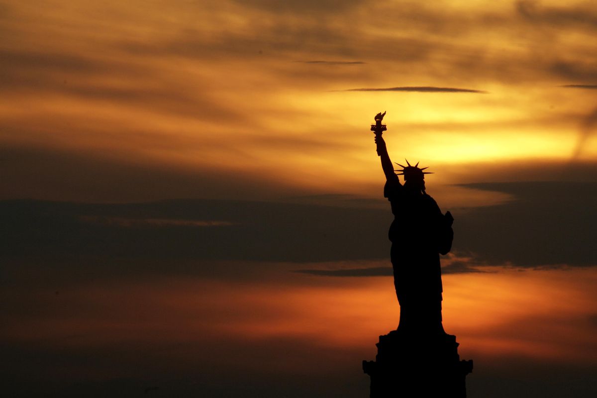 In this July 3, 2007, photo, the Statue of Liberty stands at sunset in New York. The Statue of Liberty is at the center of a national debate on immigration after a top Trump administration official offered the president’s own interpretation of the famous inscription that has welcomed immigrants to the United States for more than a century. (Seth Wenig / Associated Press)