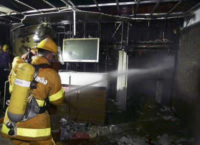 A firefighter douses the remains of a nightclub Thursday in Bangkok, Thailand. At least 59 people  died.  (Associated Press / The Spokesman-Review)