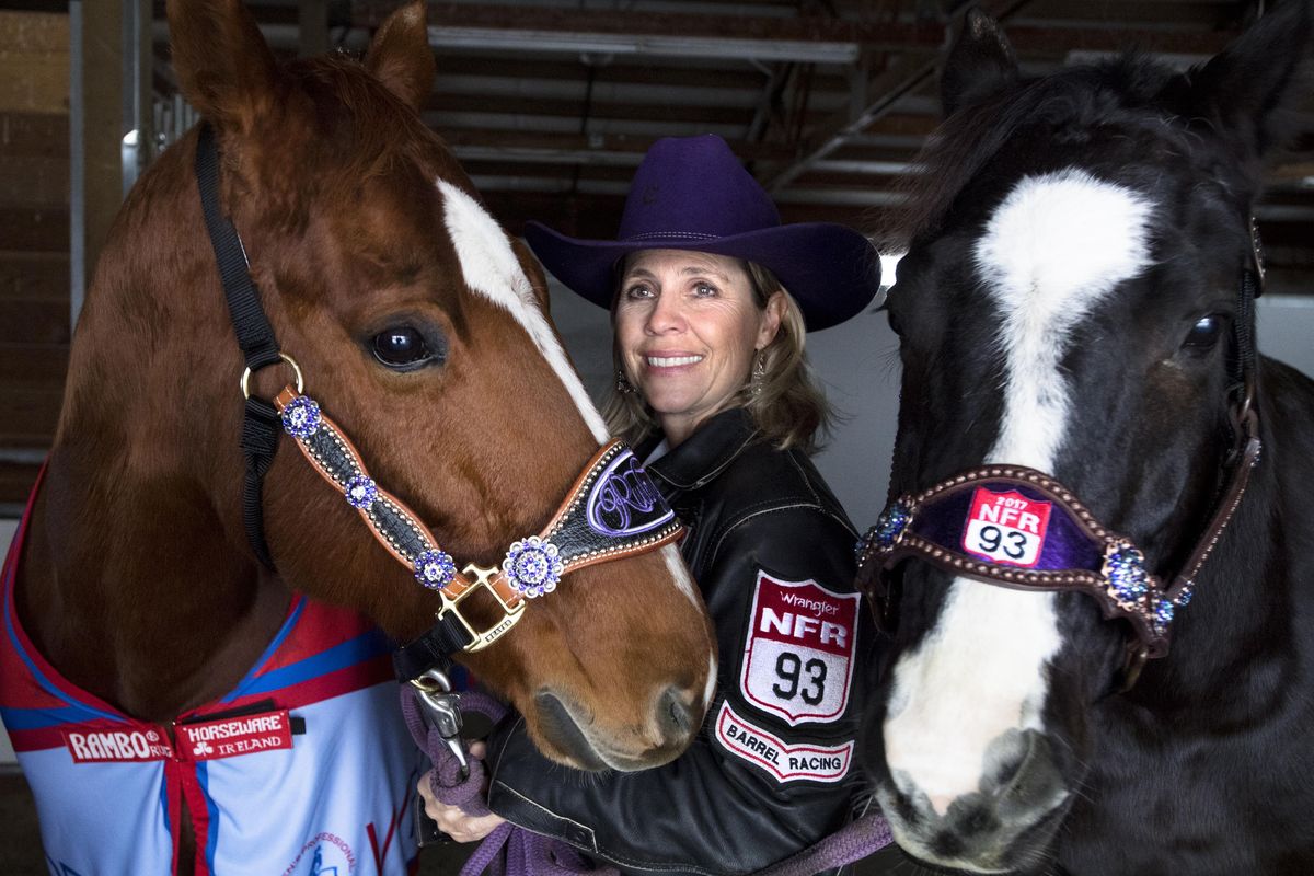 Kathy Grimes, a local barrel racer who competed at the National Finals Rodeo in Las Vegas, poses for a photo with her horses Ruby and Issy at her home on Friday, Dec. 22, 2017, near Medical Lake, Wash. (Tyler Tjomsland / The Spokesman-Review)