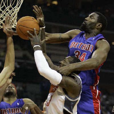 
 Bobcats' Gerald Wallace, center, is fouled by Detroit Pistons' Dale Davis. 
 (Associated Press / The Spokesman-Review)