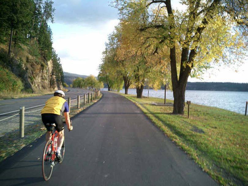 A cyclist rides a portion of the North Idaho Centennial Trail along Lake Coeur d'Alene. (North Idaho Centennial Trail Foundation)