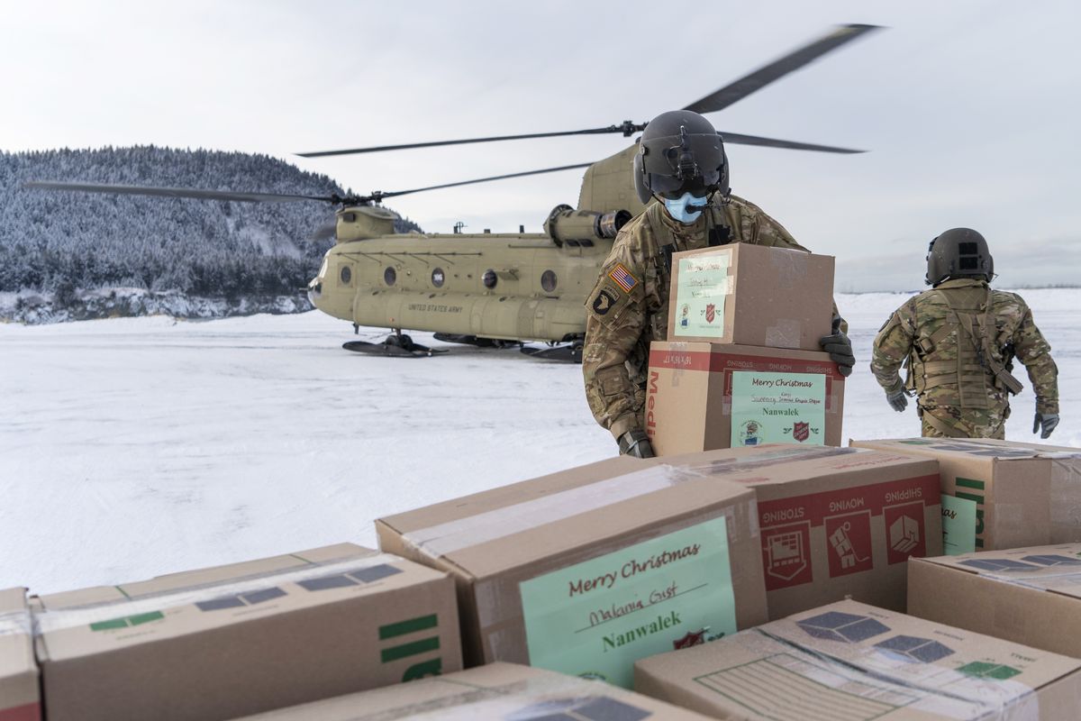 In this photo provided by the Alaska National Guard, soldiers from 1st Battalion, 207th Aviation Regiment, unload gifts from a CH-47 Chinook helicopter in Nanwalek, Alaska, during Operation Santa Claus, on Dec. 11, 2020. Operation Santa Claus is an Alaska National Guard annual community outreach program that provides Christmas gifts, books, school supplies and stocking stuffers to children in rural Alaskan communities. The Alaska National Guard and the Salvation Army were able to provide and deliver gifts for the program