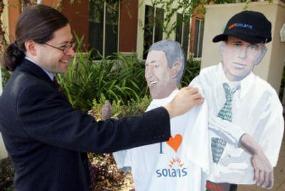 Sun Microsystems CEO and President Jonathan Schwartz puts a T-shirt bearing the Solaris operating system logo on a cutout of Hewlett-Packard founders Dave Packard, middle, and Bill Hewlett outside Sun's headquarters in Menlo Park, Calif., on Wednesday. 
 (Associated Press / The Spokesman-Review)