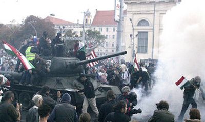 
Protesters ride a Russian-made T-34 tank stolen from an exhibition of the 1956 Hungarian uprising in downtown Budapest, Hungary, on Monday. 
 (Associated Press / The Spokesman-Review)