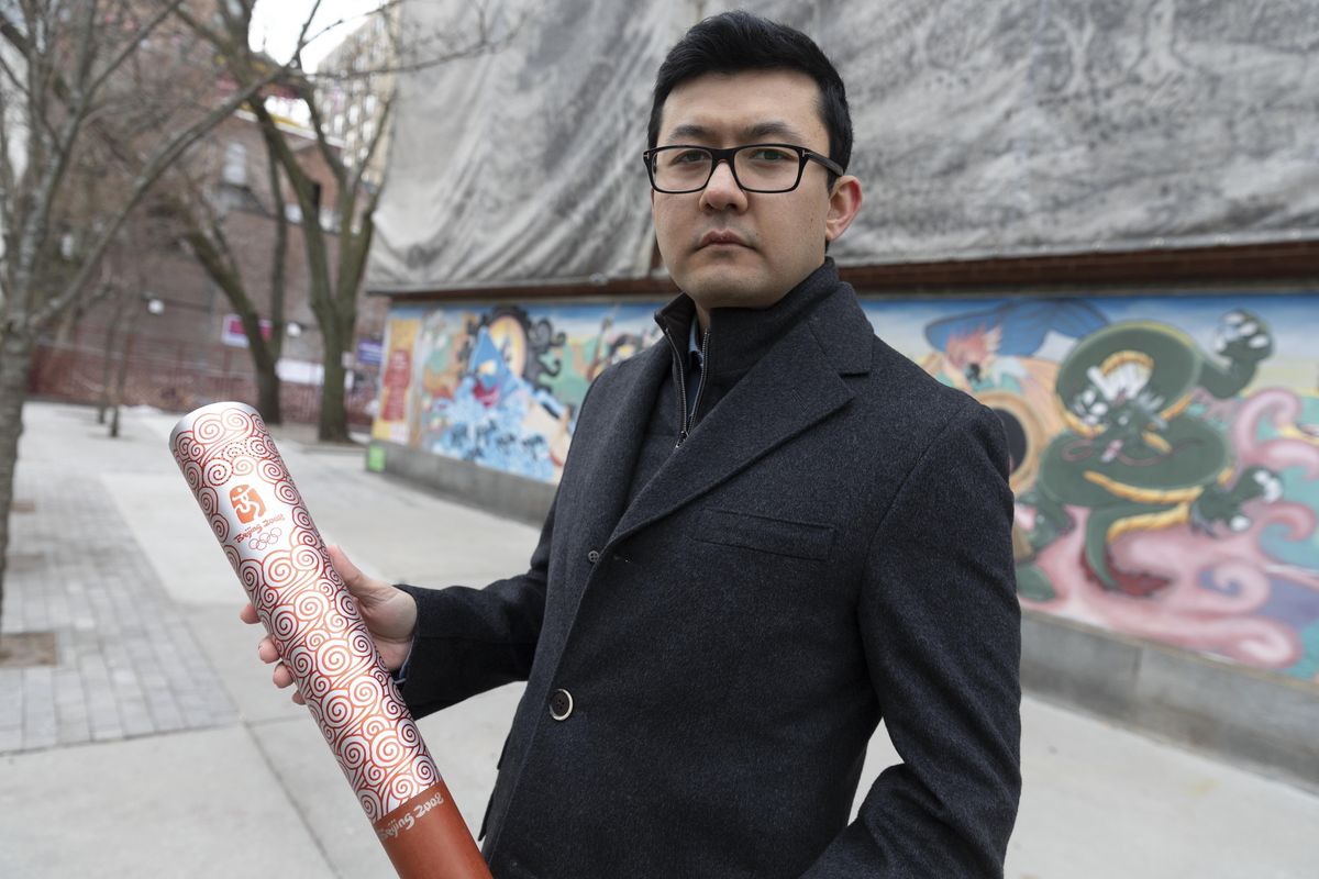 Kamaltürk Yalqun holds the aluminium Olympics torch he carried at the 2008 Beijing Olympic Games at the age of 17, on Friday, Jan. 28, 2022, in Boston. The decade after the Games saw Beijing impose policies on his region of Xinjiang that split apart his family and Uyghur community. Today, he is an activist in the United States calling for a boycott of the 2022 Winter Games, which will see the Olympic flame returned to Beijing.  (Michael Dwyer)