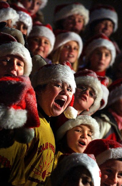 
Children singing with the Solar Energy Choir from Sunshine Elementary School strain their necks to see Santa Claus at the third annual Christmas tree lighting ceremony at U-City Mall on Thursday.
 (Jed Conklin / The Spokesman-Review)