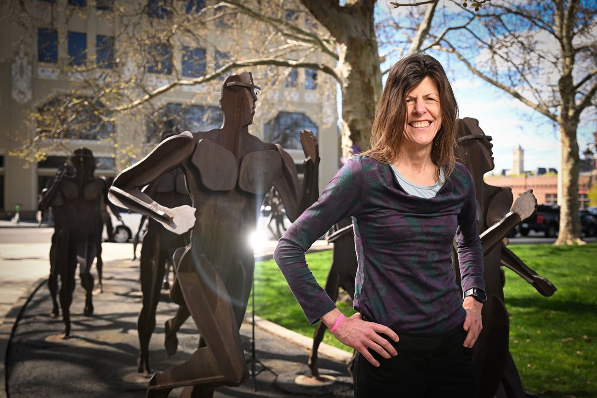 Longtime runner Jackie Van Allen, standing among the steel sculptures by David Goverdare titled “The Joy of Running Together” in Riverfront Park, has logged more than 63,000 running miles, dutifully recorded in annual logbooks, throughout her running life. Van Allen, 61, will run in Sunday’s Bloomsday. (Jesse Tinsley/The Spokesman-Review)