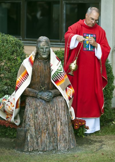 A statue of Father Cataldo is blessed by the Rev. Tom Lankenau at Gonzaga Prep on Sept. 21. (Colin Mulvany)