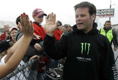 
Robby Gordon high fives fans while leaving the garage area in the rain. Associated Press
 (Associated Press / The Spokesman-Review)