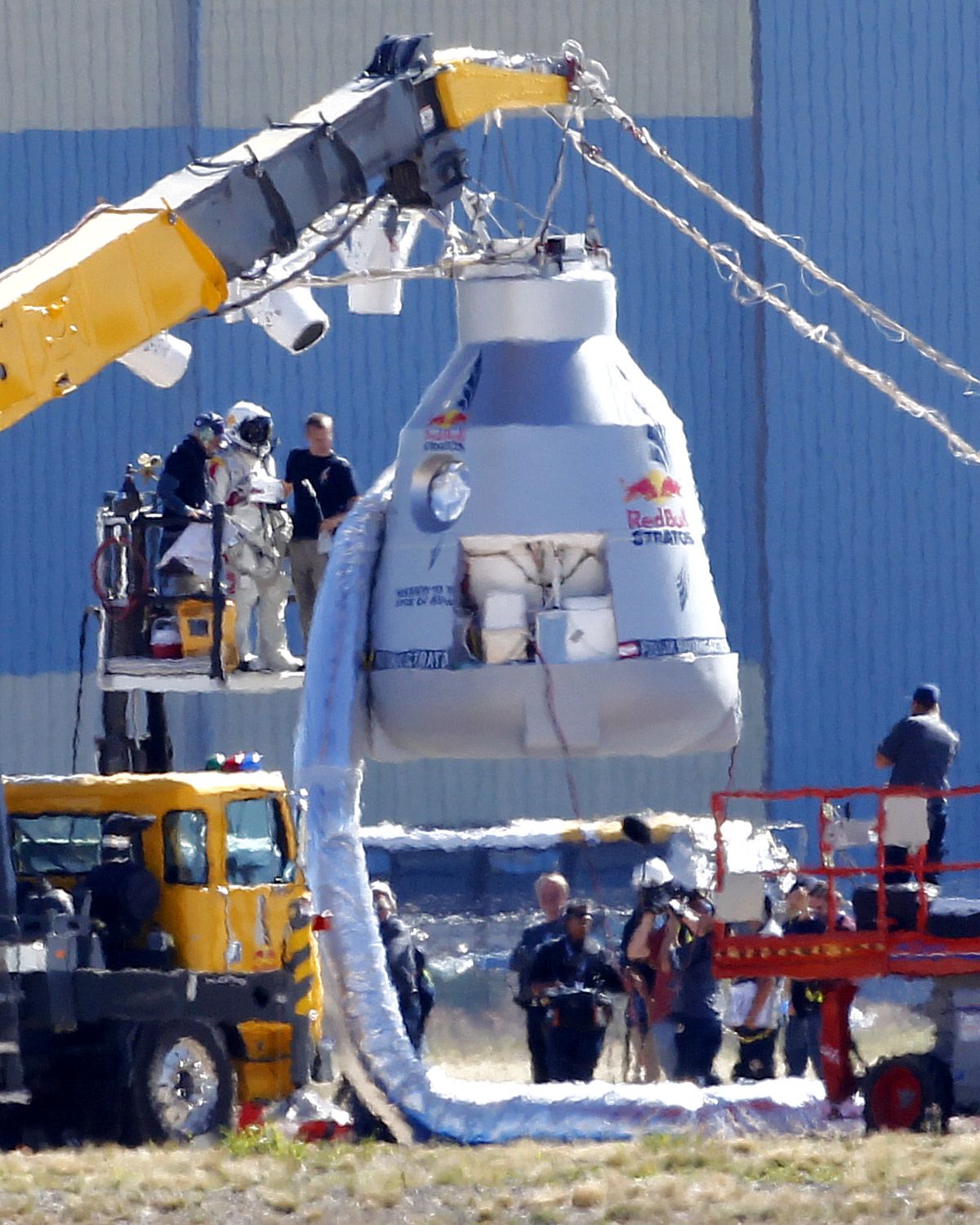 Felix Baumgartner, in pressurized suit on platform at left, prepares to enter the balloon capsule in Roswell, N.M. on Tuesday, Oct. 9, 2012. Baumgartner will attempt to break the speed of sound with his own body by jumping from the space capsule lifted by a 30 million cubic foot helium balloon. Baumgartner plans to jump from an altitude of 120,000 feet - an altitude chosen to enable him to achieve Mach 1 in freefall - which will deliver scientific data to the aerospace community about human survival from high altitudes. (Matt York / Associated Press)