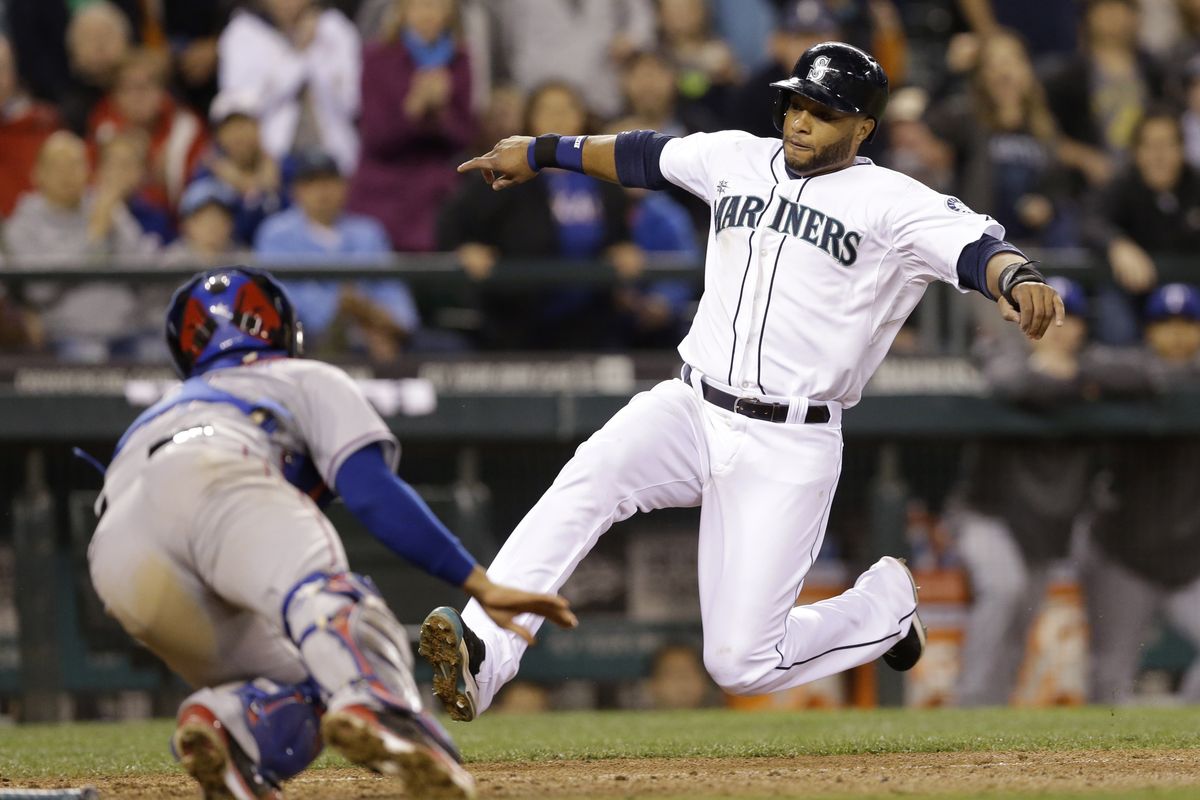 M’s Robinson Cano slides safely into home as Rangers’ Robinson Chirinos is late with the tag in sixth inning. (Associated Press)