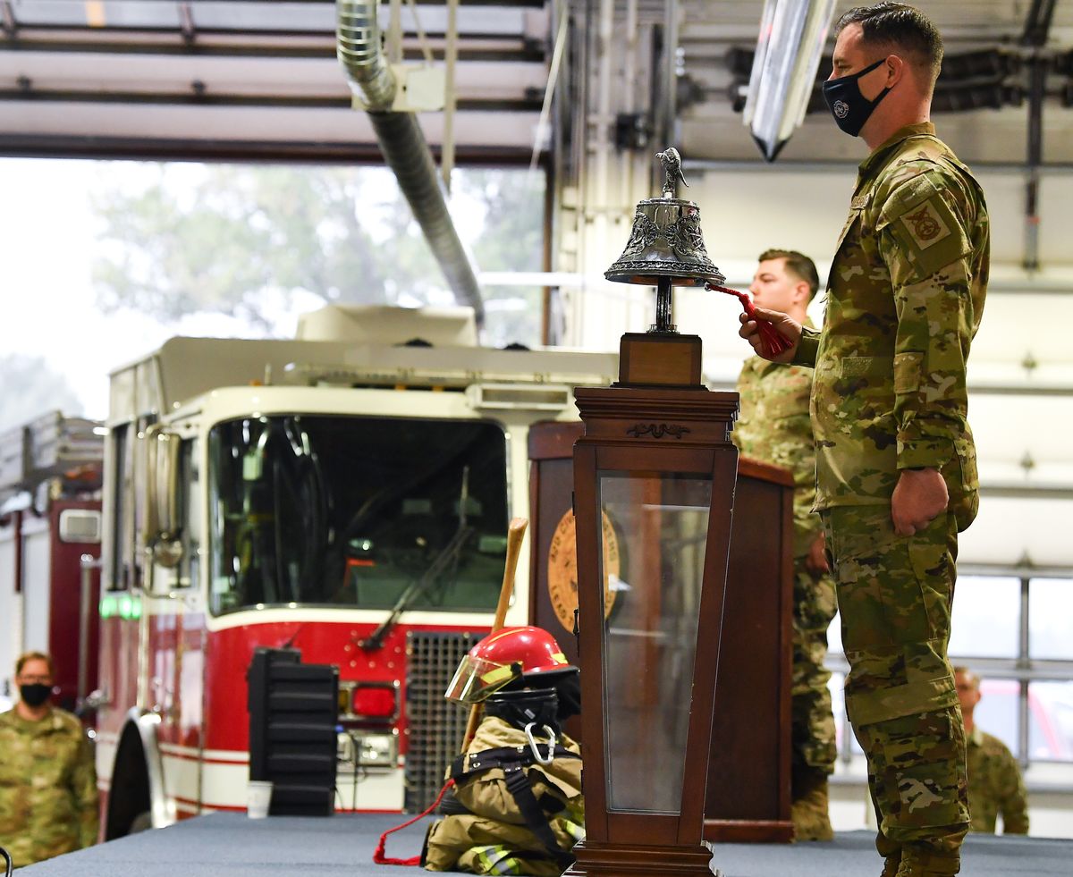 A member of the 92nd Civil Engineer Squadron rings a bell three times for first responders who can no longer respond to a call during a 9/11 ceremony on Friday at Fairchild Air Force Base in Airway Heights.  (Tyler Tjomsland/The Spokesman-Review)
