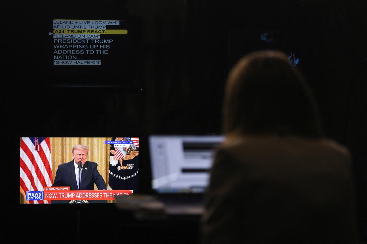 A journalist works as a screen displays U.S. President Donald Trump speaking about election security during an address to the nation on Thursday from the East Room of the White House  (Reuters)