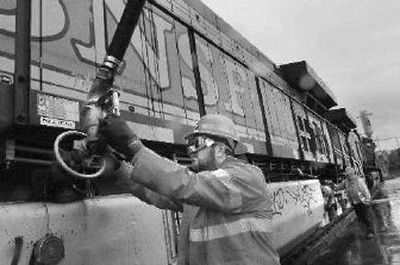 
A worker fills the tank of a BNSF locomotive with diesel fuel in Vancouver, Wash. 
 (Associated Press / The Spokesman-Review)