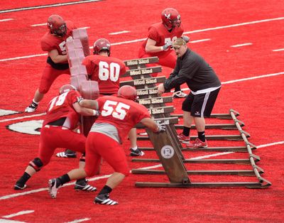 EWU offensive coordinator/offensive line coach Aaron Best hops on the blocking sled to better observe a drill. (Colin Mulvany)