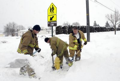 Spokane Valley Fire Department firefighter Matt Brodsky, Capt. Mike Charter and firefighter Jim Mulena dig out a hydrant Monday. (J. BART RAYNIAK / The Spokesman-Review)