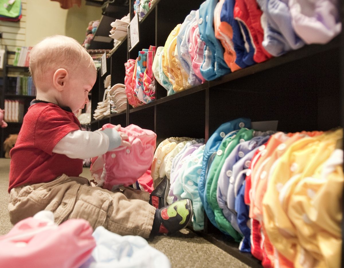 Eight-month-old Ezra Bird occupies himself with cloth diapers at the Circle Me store in Lincoln, Neb. (Associated Press / The Spokesman-Review)