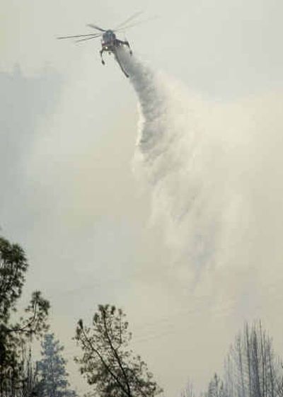 
Heli-tankers try to halt the spread of the fire as it travels west along Highway 299 in French Gulch, Calif., on Sunday. 
 (Associated Press / The Spokesman-Review)