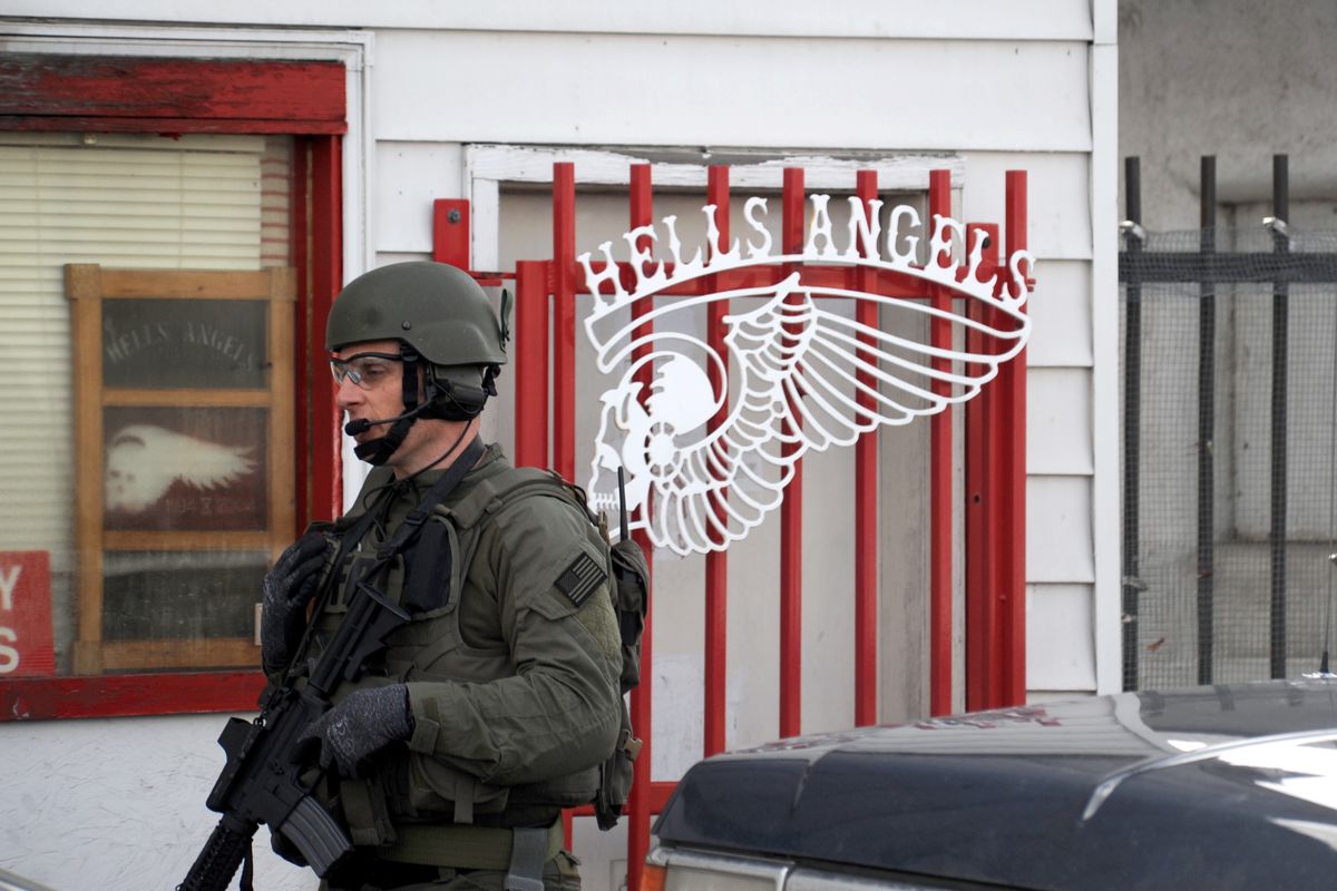 A federal agent walks past the front of the Hells Angels clubhouse on the 1300 block of East Sprague Thursday, March 3, 2011.  The Federal Bureau of Investigation raided the motorcycle club