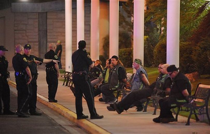 In this Friday, Sept. 23, 2011 photo, officers keep an eye on handcuffed men at the east entrance to John Ascuaga's Nugget after a shooting in Sparks, Nev. One person has been killed and two others wounded in a shooting at a hotel-casino in Sparks that witnesses say involved members of rival motorcycle gangs, the Vagos and Hells Angels. ((AP Photo/The Reno Gazette-Journal))