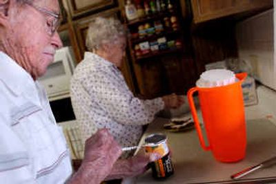 
Floyd Milne slowly opens a can of orange juice while Dulcie Milne prepares lunch at their home. They have been married for 71 years and hope to continue to take care of themselves. 
 (Photos by Holly Pickett/ / The Spokesman-Review)