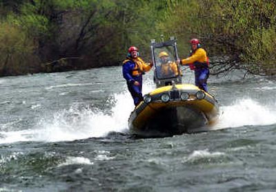 
Spokane firefighters search the Spokane River on Thursday. 
 (Rajah Bose / The Spokesman-Review)