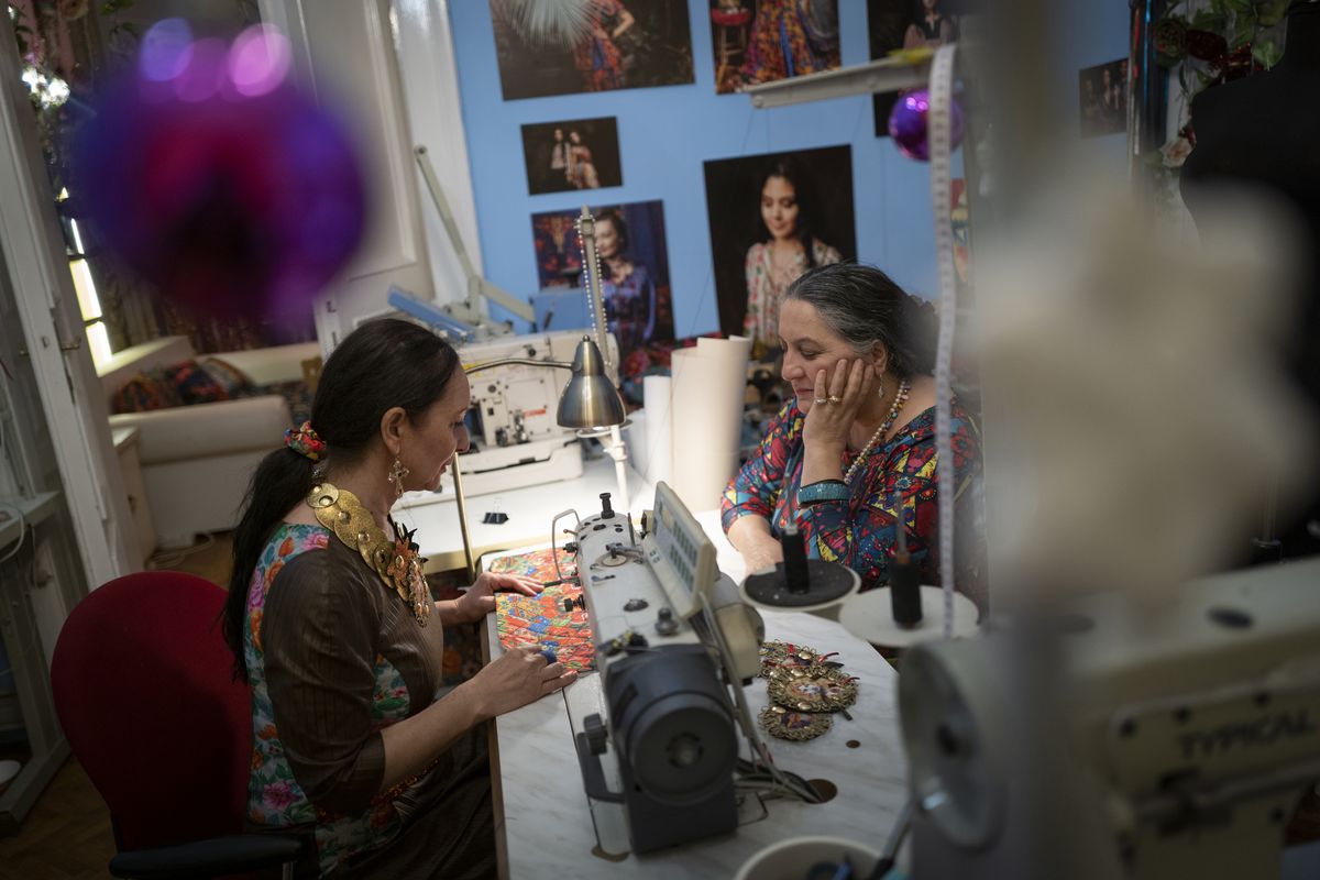 Roma sisters Helena, left, and Erika Varga work on a production in their fashion studio, Romani Design, in Budapest, Hungary, Sunday, Dec. 12, 2021. Romani Design, a fashion studio in Hungary, is challenging the centuries-old stereotypes faced by the country