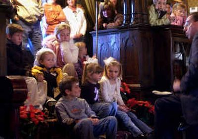 
Children gather on the stairs in the front room of the Campbell House to listen as Bruce Eldredge reads 
