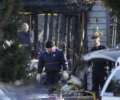 Fire investigators walk in front of charred rubble, Monday, Feb. 6, 2012, at the home where Josh Powell and his two sons were killed Sunday, in Graham, Wash., in what police said appeared to be a deliberately set fire. Powell's wife Susan went mysteriously missing from their West Valley City, Utah, home in December 2009.  (Ted S. Warren / AP Photo)